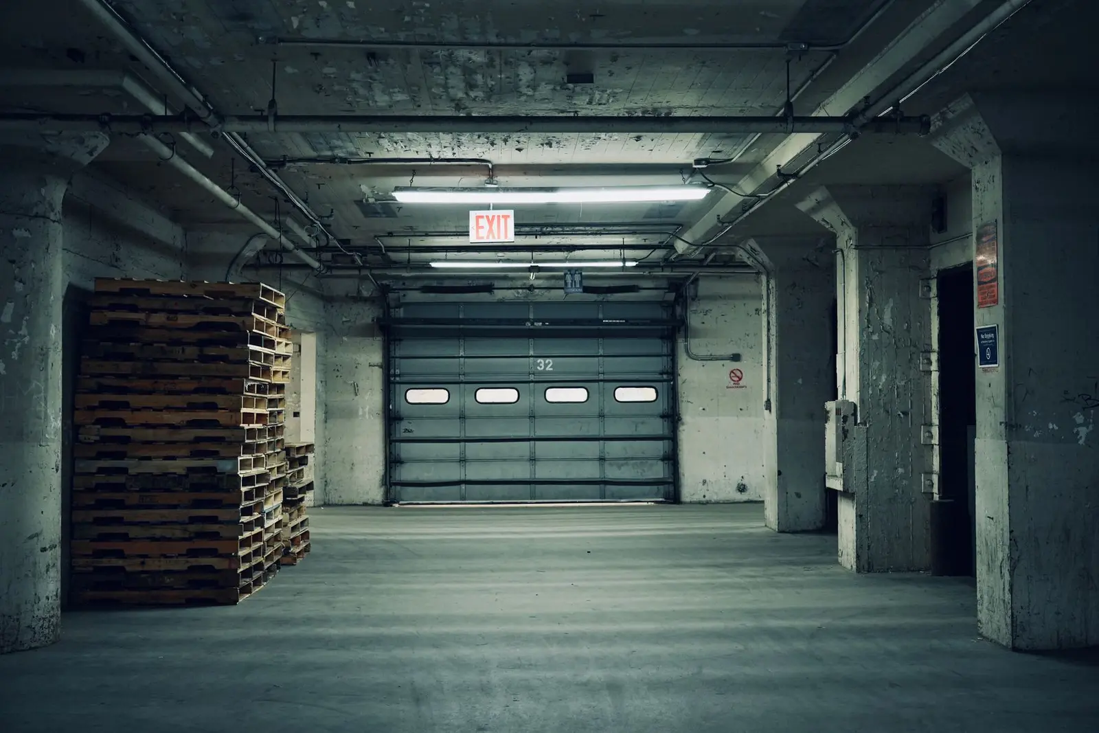 A closed loading dock door inside a warehouse at night